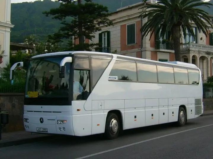 Bílý zájezdový autokar na zahraniční cestě